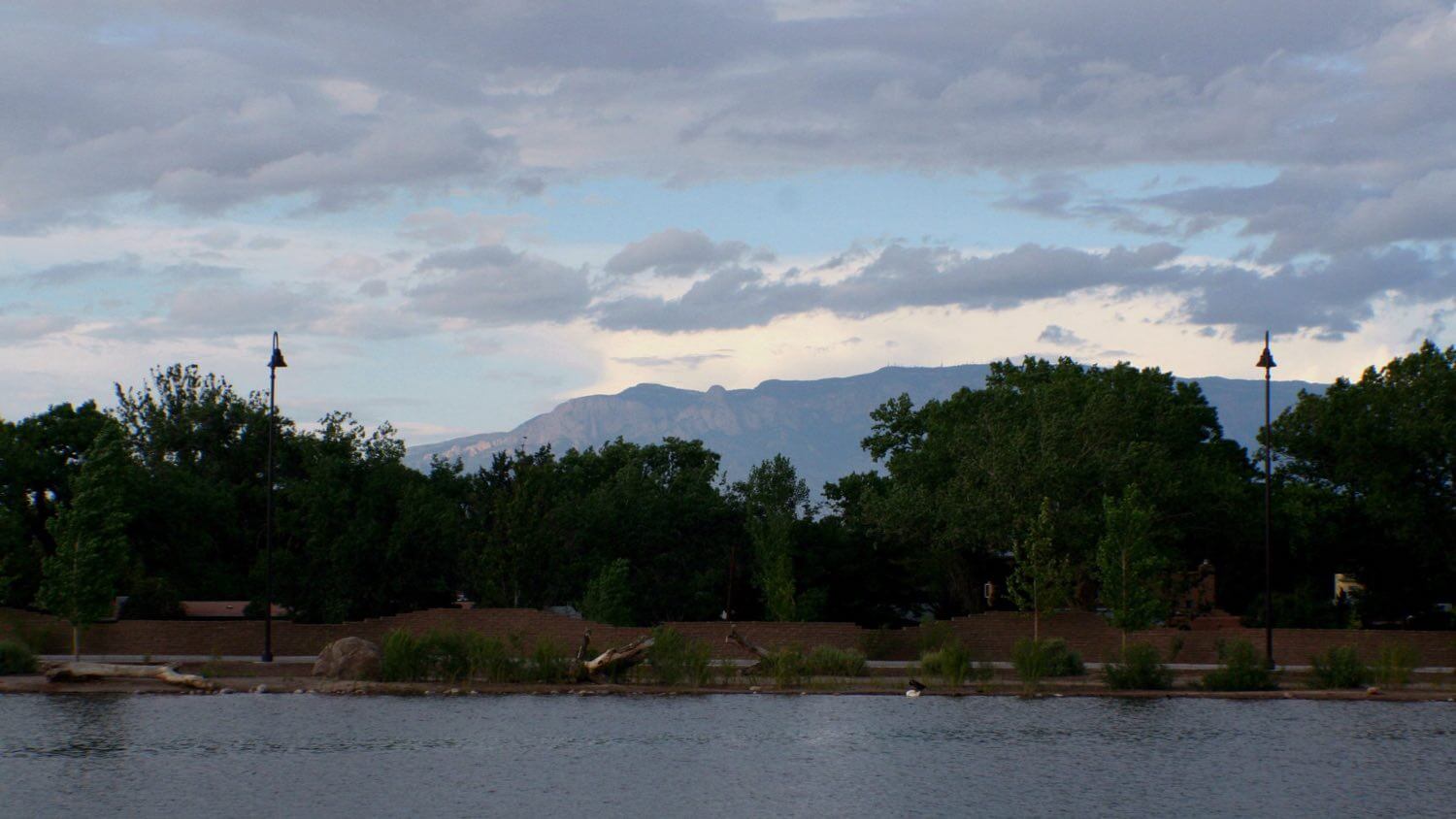 The Sandia Mountains rising over Albuquerque, New Mexico, seen across the water at Tingley Beach — EMF radiation testing and shielding help for Albuquerque homes