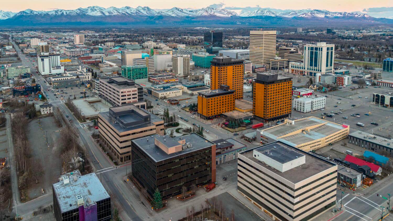 Downtown Anchorage, Alaska skyline with the snow-capped Chugach Mountains behind — EMF radiation testing and shielding help for Anchorage homes