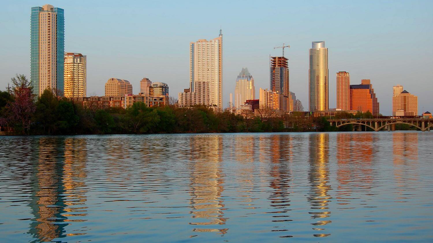 Downtown Austin, Texas skyline at golden hour reflected in Lady Bird Lake &mdash; EMF radiation testing and shielding help for Austin homes