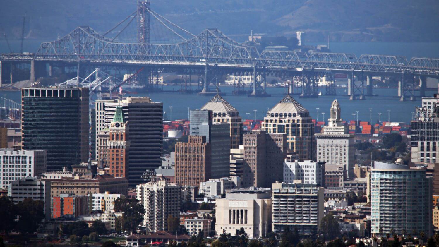 Downtown Oakland, California skyline with the Bay Bridge behind — EMF radiation testing and shielding help for Oakland homes